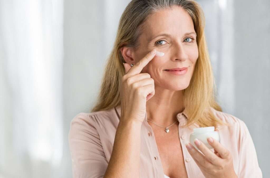 woman applying anti aging lotion on face