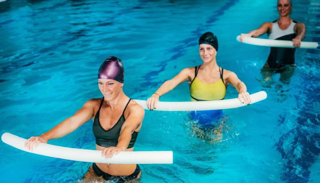women training with swimming noodles